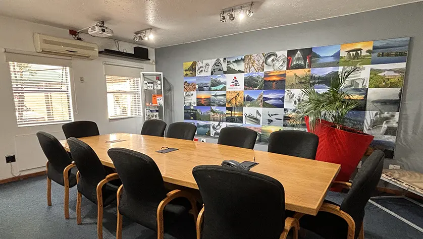 Meeting room with long table and AESSEAL image board on the wall.